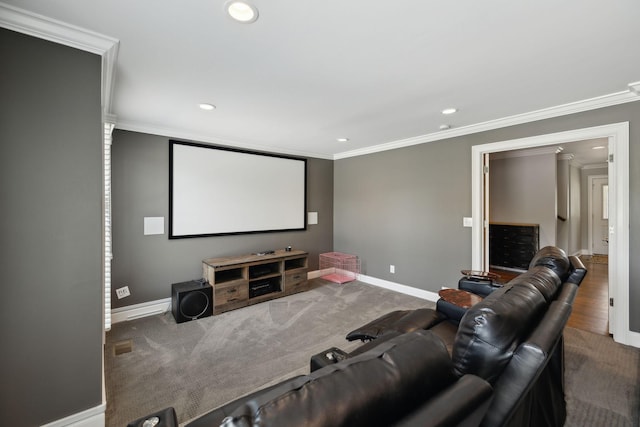 home theater room featuring carpet floors, recessed lighting, baseboards, and ornamental molding