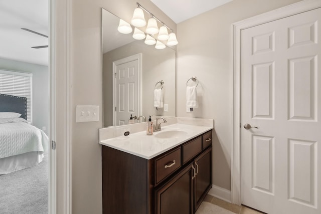 bathroom with baseboards, ensuite bathroom, tile patterned flooring, and vanity