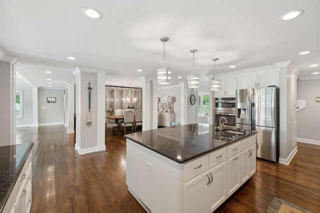 kitchen with crown molding, appliances with stainless steel finishes, a sink, baseboards, and ornate columns