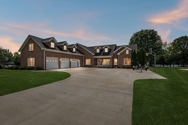 cape cod home with a garage, concrete driveway, a front lawn, and brick siding