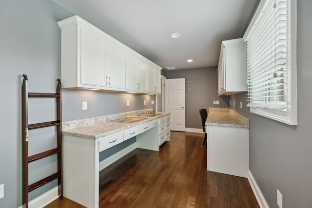 kitchen featuring white cabinets, dark wood finished floors, a wealth of natural light, and built in study area