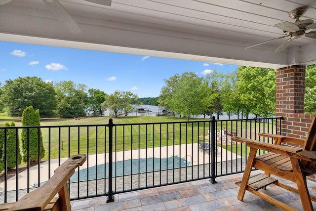 balcony with a water view and ceiling fan