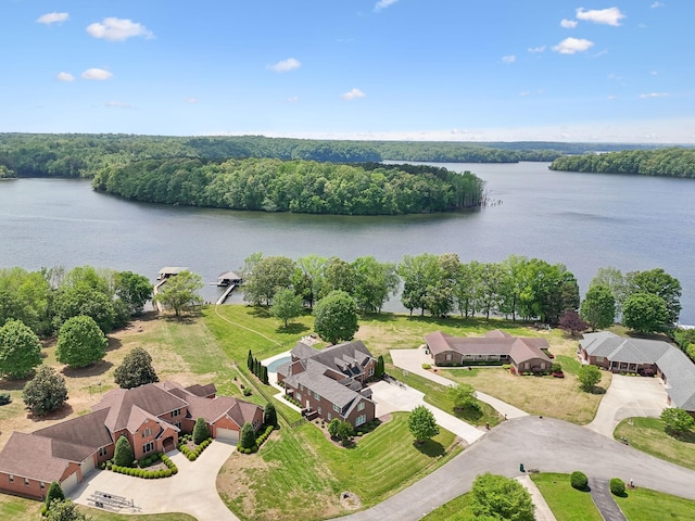 drone / aerial view with a residential view, a water view, and a wooded view