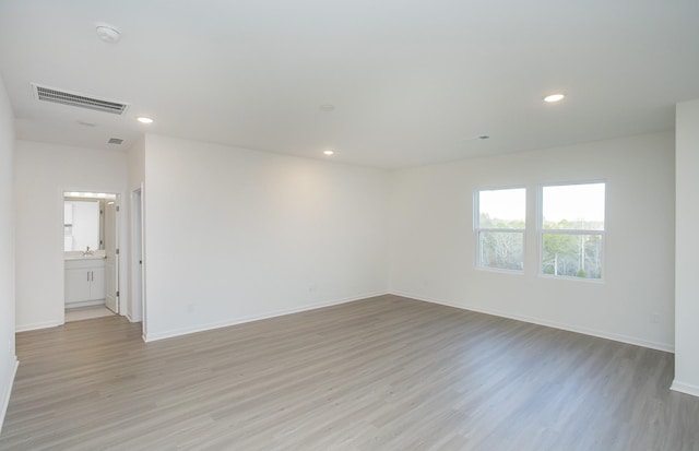 empty room featuring baseboards, recessed lighting, light wood-style flooring, and visible vents