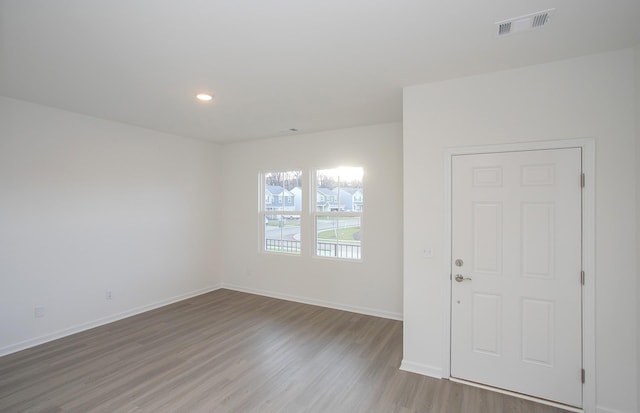 unfurnished room with recessed lighting, baseboards, visible vents, and wood finished floors