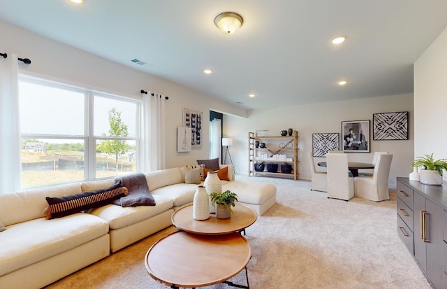 living area featuring recessed lighting, visible vents, and light carpet