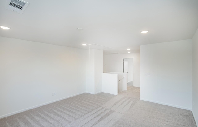 spare room featuring visible vents, recessed lighting, baseboards, and light carpet