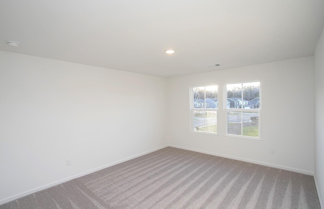 spare room featuring carpet flooring, recessed lighting, and baseboards