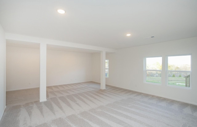 below grade area featuring light colored carpet, recessed lighting, baseboards, and visible vents
