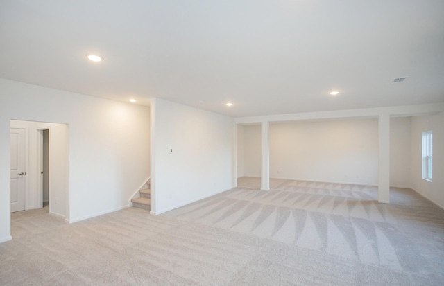 below grade area with recessed lighting, light colored carpet, and stairway