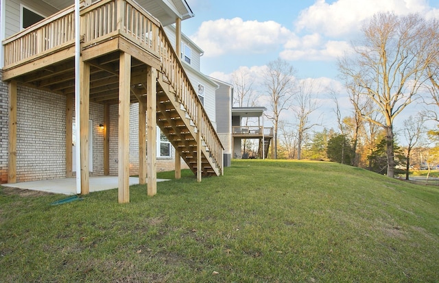 view of yard with stairway, a deck, and a patio
