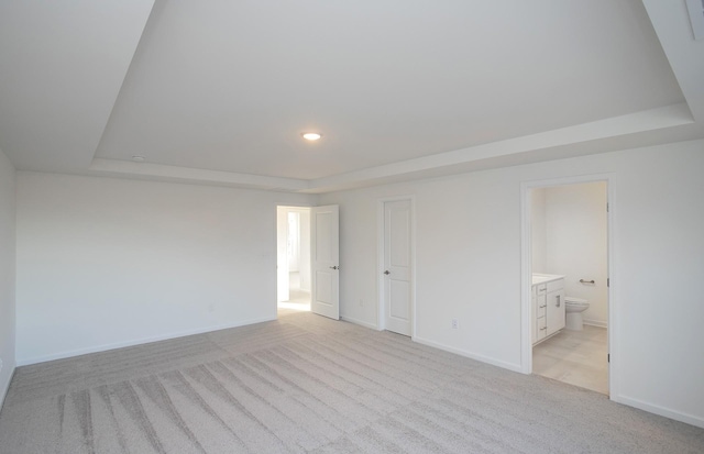 unfurnished room featuring light colored carpet, recessed lighting, baseboards, and a tray ceiling