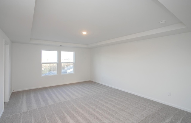 unfurnished room with baseboards, carpet, a raised ceiling, and recessed lighting