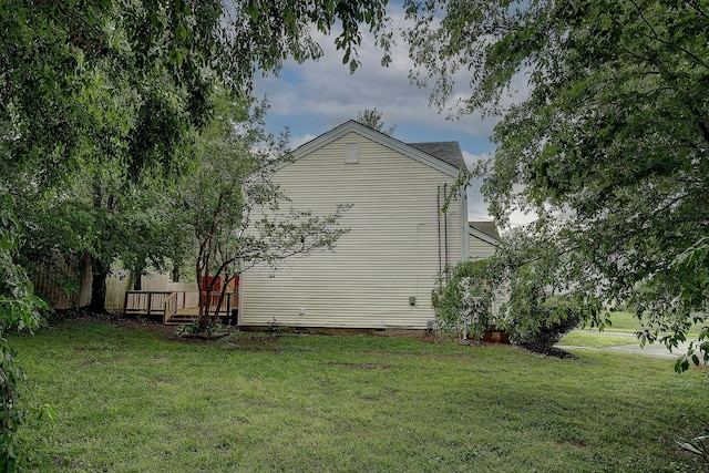 view of side of home featuring a lawn, a wooden deck, and crawl space