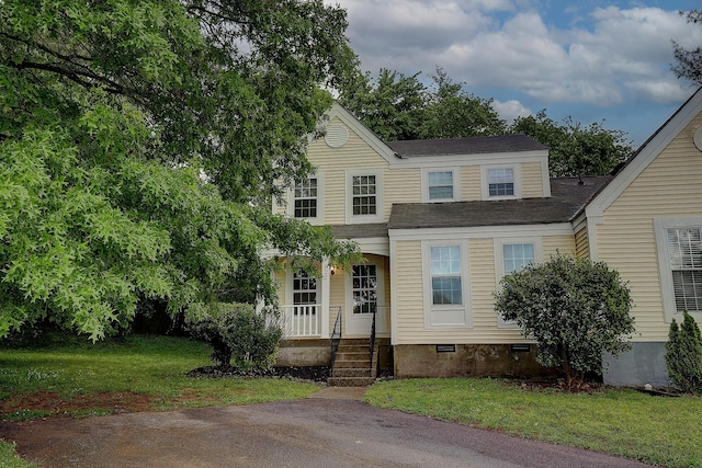 traditional-style house with crawl space and a front yard
