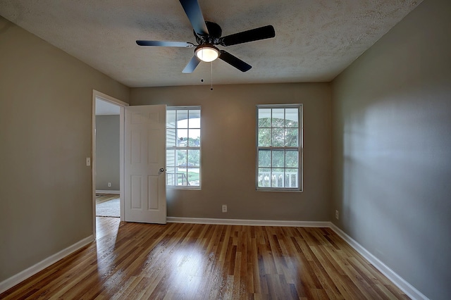 unfurnished room featuring baseboards, a textured ceiling, ceiling fan, and wood finished floors