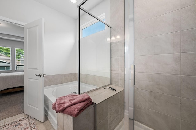 ensuite bathroom featuring tile patterned floors, a stall shower, ensuite bath, and a bath