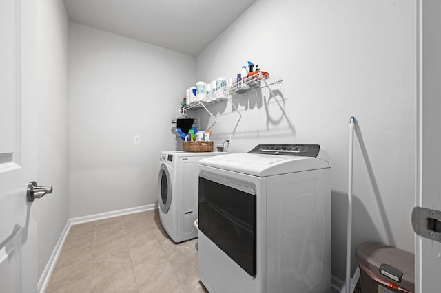 laundry room featuring washing machine and clothes dryer, laundry area, and baseboards