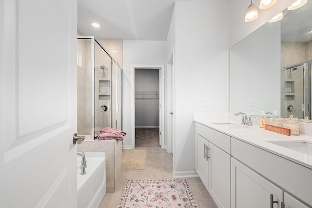 bathroom with a sink, tile patterned floors, a shower stall, and a spacious closet