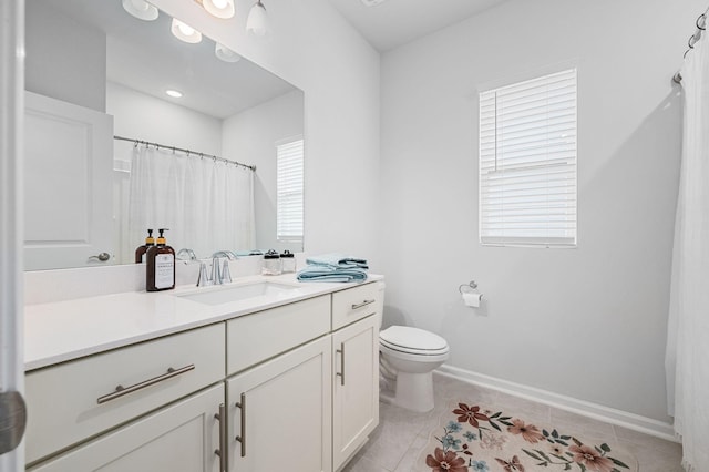 full bathroom featuring a healthy amount of sunlight, vanity, tile patterned floors, and toilet