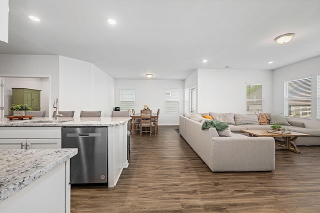 kitchen featuring white cabinets, a sink, dishwasher, open floor plan, and dark wood-style floors