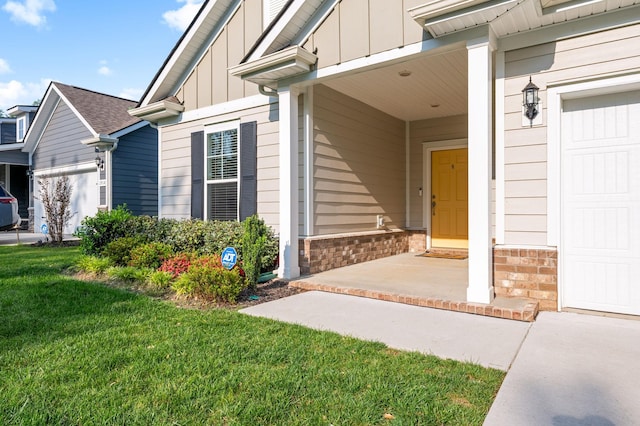 property entrance with board and batten siding and a yard