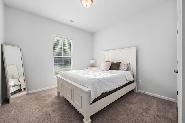 bedroom with baseboards, visible vents, and light colored carpet