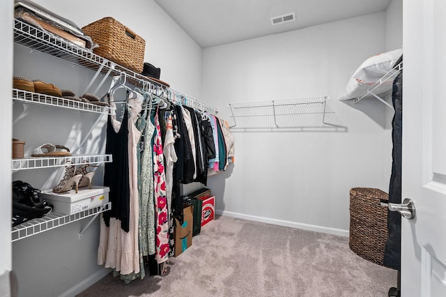 walk in closet featuring visible vents and carpet