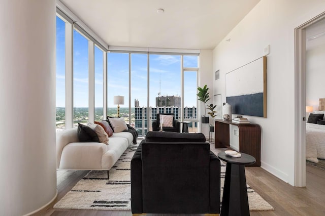 living room featuring baseboards, visible vents, expansive windows, and wood finished floors
