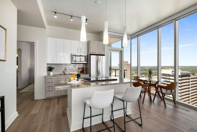 kitchen featuring a kitchen island, stainless steel appliances, plenty of natural light, and decorative backsplash
