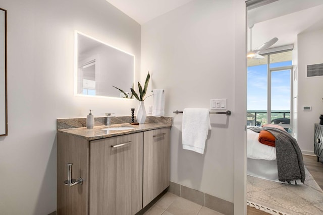 ensuite bathroom featuring a ceiling fan, visible vents, vanity, baseboards, and ensuite bath