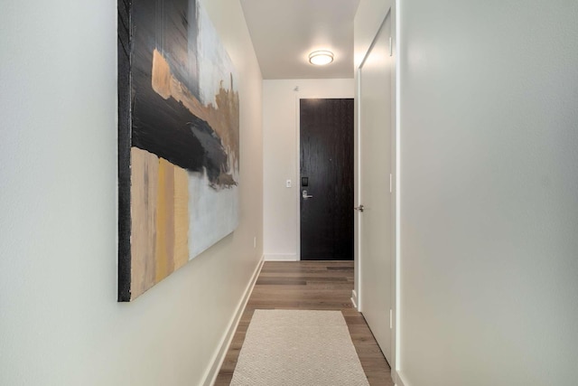 hallway with baseboards and wood finished floors