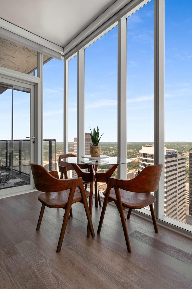 sunroom with floor to ceiling windows, a wealth of natural light, and wood finished floors