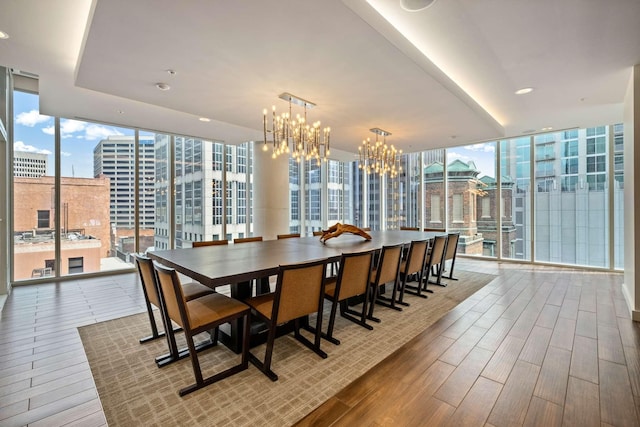 dining area with a notable chandelier, expansive windows, and wood finished floors