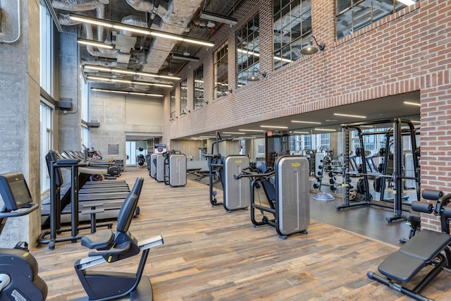 workout area with a high ceiling and wood finished floors