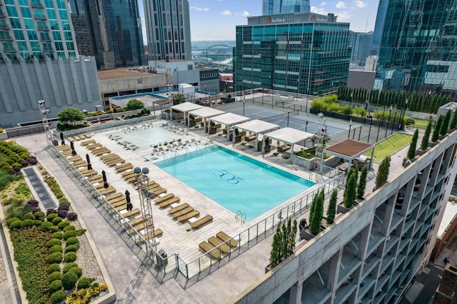 community pool featuring a view of city and fence