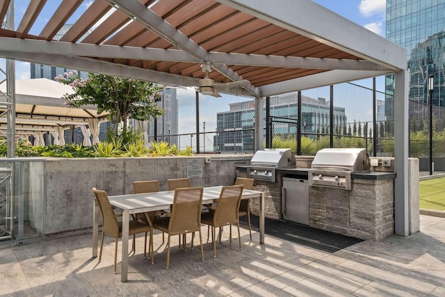 view of patio featuring area for grilling, exterior kitchen, fence, and outdoor dining area