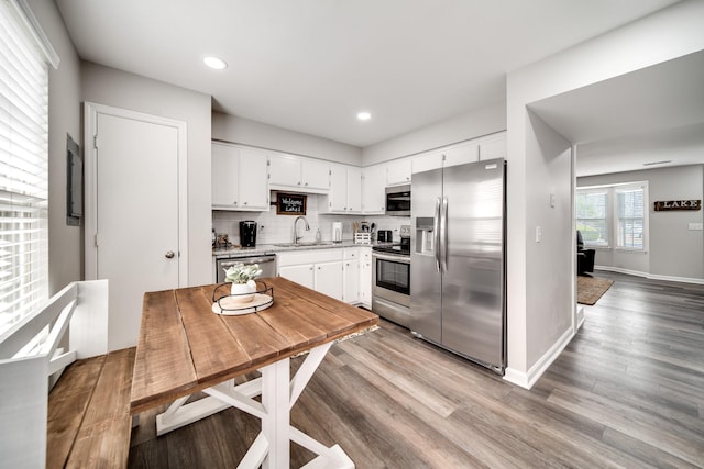 250 Sanders Ferry Rd Unit 4, Hendersonville, TN 37075 - kitchen with decorative backsplash, white cabinetry, a sink, light wood finished floors, and stainless steel appliances