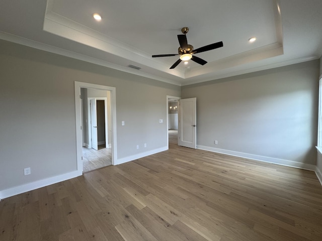 unfurnished bedroom with baseboards, visible vents, ornamental molding, and a raised ceiling