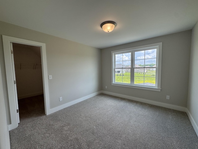 carpeted spare room featuring baseboards