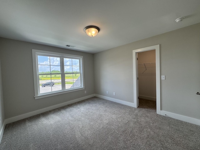 carpeted spare room featuring baseboards and visible vents