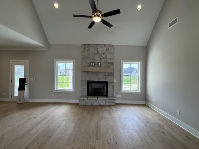 unfurnished living room with ceiling fan, visible vents, plenty of natural light, and wood finished floors
