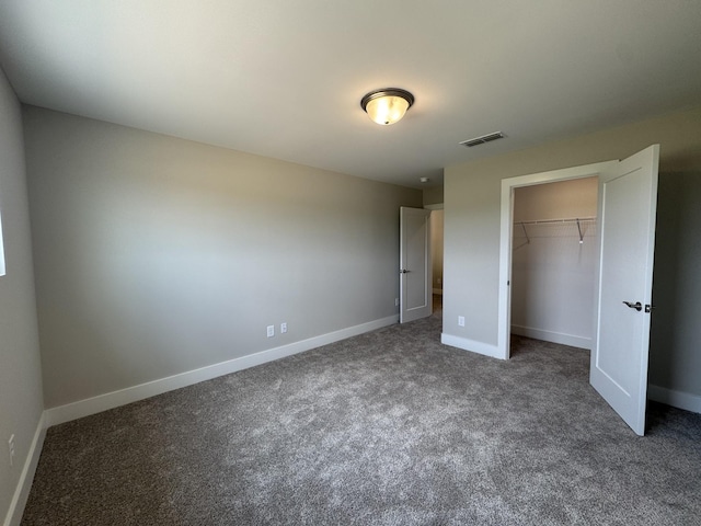 unfurnished bedroom featuring baseboards, carpet, a closet, and visible vents