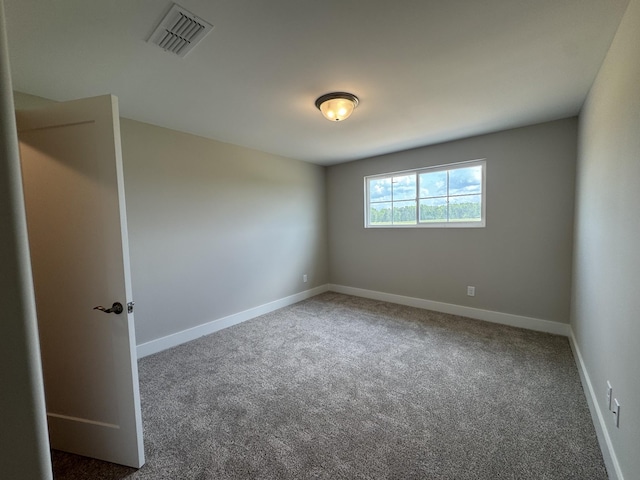 carpeted spare room featuring baseboards and visible vents