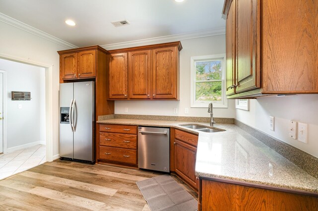 kitchen with brown cabinetry, visible vents, crown molding, a sink, and stainless steel appliances
