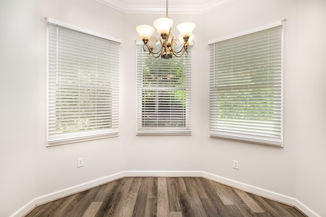 unfurnished dining area featuring plenty of natural light, wood finished floors, and a chandelier