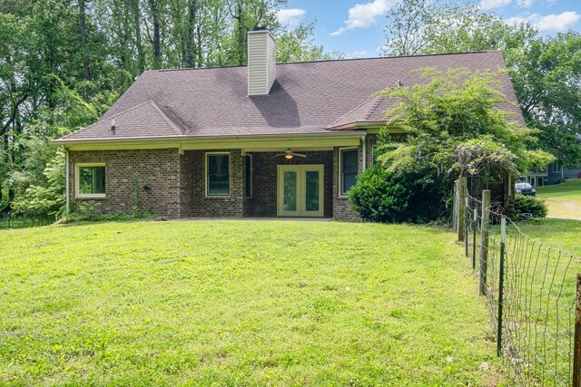 exterior space with a yard, fence, french doors, and a chimney