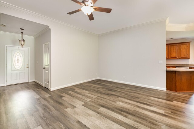 unfurnished living room with baseboards, crown molding, ceiling fan, and wood finished floors