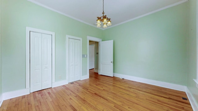 706 N Church St, Murfreesboro, TN 37130 - unfurnished bedroom with baseboards, light wood finished floors, an inviting chandelier, multiple closets, and ornamental molding