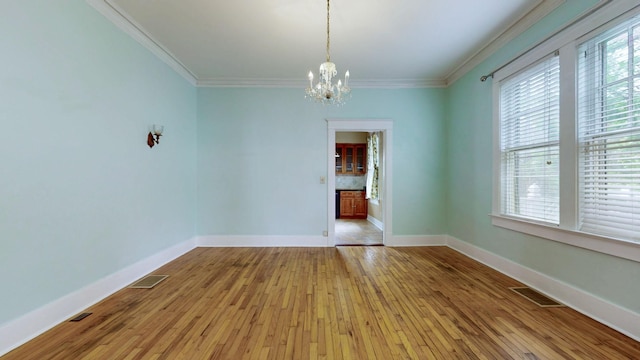 706 N Church St, Murfreesboro, TN 37130 - empty room featuring an inviting chandelier, light wood finished floors, crown molding, and visible vents